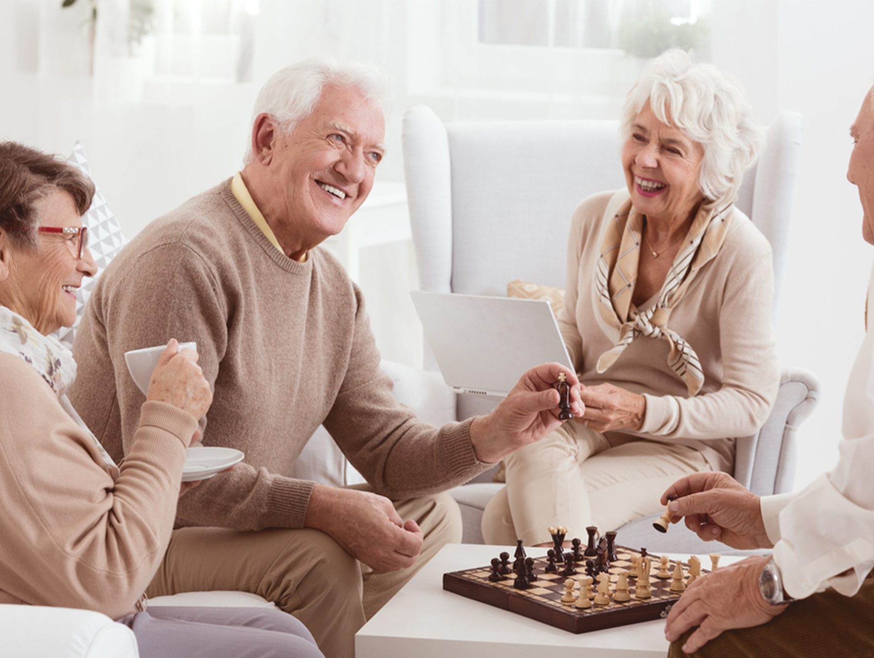 Happy elderly friends playing chess