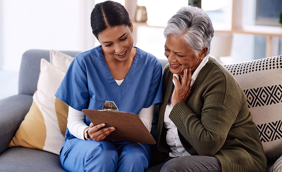 Caregiver and smiling senior woman reviewing documents, NDIS Personal Care Services