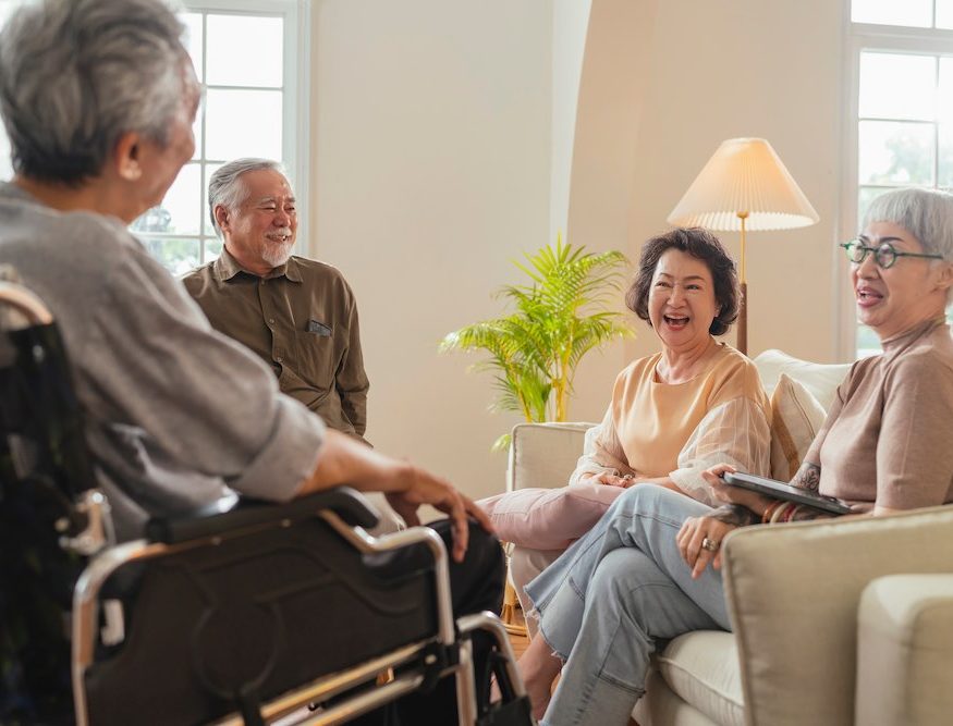 A group of happy elderly people talking in NDIS shared accommodation services