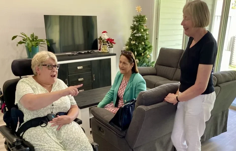 Woman in a wheelchair talking to two other women in NDIS shared accommodation
